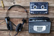 Music concept. Top view of cassette tape, audio player and headphones.