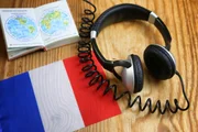 language course headphone and flag on wooden table