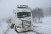 Thord Paulsen checking the snow chains on a big truck, and a queue is building up.