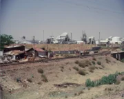 Bhopal, India: A view of the Union Carbide industrial plant seen from across the train tracks, behind a nearby village.   (Photo Credit: © Darlow Smithson Productions)