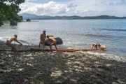 Survivalists drag logs out of water.