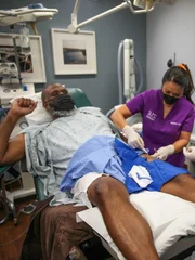 Dr. Lee works on removing lumps from Mike Asai’s legs.