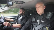 Polizeibeamte in einem Auto.