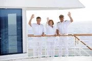 Dr. Sander (Nick Wilder), Beatrice (Heide Keller) und Kapitän Burger (Sascha Hehn) stehen winkend an Deck der MS Amadea.