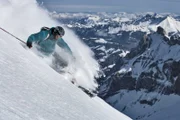 Freeride-Skifahrer schwingt im Pulverschnee.