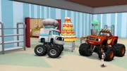 Blaze (re.hi.) und AJ (re.vo.) erhalten einen Rundgang durch die Bäckerei von Reifenhausen. Kurze Zeit später geraten die für die Kuchen und Torten zuständigen Backroboter außer Kontrolle und richten in der Stadt ein Chaos an (Clive, l.)