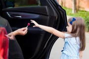 Ein Fremder im Auto bietet dem Kind Süßigkeiten an. Kinder in Gefahr. Kinder Sicherheit Schutz Entführung Konzept.