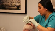 A medical assistant examining David’s nose.