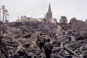 Eine US-Infanteriepatrouille bahnt sich einen Weg durch die Ruinen von Saint Lô. Die französische Stadt wird im Zweiten Weltkrieg zu 95 Prozent zerstört.