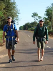 Rob Greenfield and James Levelle walking down the road in Iguazu, Argentina.