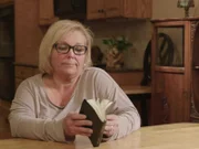 Cindy Moore looking through mom?s devotional book during interview.