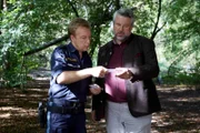 Polizeihauptmeister Mohr (Max Müller, l.) zeigt Kommissar Stadler (Dieter Fischer, r.) die beim Opfer gefundenen Visitenkarten.