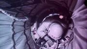 Nachdem der Kosmonaut Alexej Leonow etwas Sauerstoff aus seinem Anzug abgelassen hat, schafft er es schließlich doch, sich durch die Luftschleuse ins Innere des Raumschiffs zu zwängen.