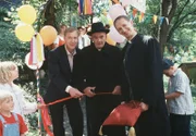 Bischof Hemmelrath (Hans-Michael Rehberg, Mitte) weiht zusammen mit Monsignore Mühlich (Gilbert von Sohlern, re.) und Bürgermeister Dr. Bartels (Oliver Stritzel) einen Kindergarten ein.