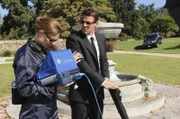 Brennan (Emily Deschanel, L) and Booth (David Boreanaz, R) search for evidence after a psychic provides them with valuable information in the BONES season premiere episode "Harbingers in the Fountain".