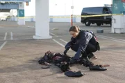 Brennan (Emily Deschanel) untersucht auf einem Parkdeck die Leiche eines Mannes, der für den mysteriösen Inhalt seines Aktenkoffers ermordet wurde: seine Hand mit dem befestigten Koffer wurde abgeschnitten...
