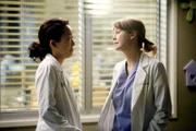 Es ist sechs Uhr abends. Meredith (Ellen Pompeo, r.) leitet freiwillig die Notaufnahme und dirigiert die Ärzte, während Cristina (Sandra Oh, l.) ihr etwas zu erzählen versucht ...