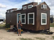 Esin Pirkul (owner) smiles for a photo outside her completed tiny home in Austin, Texas, as seen on HGTV's Tiny House Big Living.