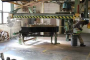 Piano factory, piano under machinery.