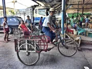 Ein Fahrradfahrer auf einem Markt in Yangon, Myanmar.