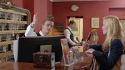 The receptionist directs the guest.