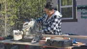 Tiny house builder Shelby Catron works on cutting lumber as she assists her husband Chad in building an off the grid tiny house for them and their three children on their stunning 20 acre property in Spirit Lake, Idaho, as seen on Tiny House, Big Living.
