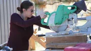 Lily is cutting a board with a miter saw for the Anibas build, in Colorado Springs, Colorado, as seen on Tiny House, Big Living.