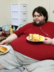 Tommy lays in bed with food