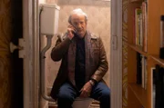 Serge Alvaro (Patrick Chesnais) hat sich telefonierend in der Toilette versteckt.