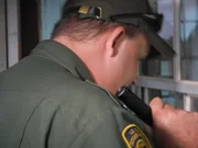 Roma, Texas, USA: Supervisory Border Patrol Agent David Maibaum holding his flashlight as he looks through the window of an abandoned house.
