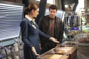 Brennan (Emily Deschanel) erklärt Booth (David Boreanaz), was sie über den geheimnisvollen Leichnam, den eine Regierungstruppe zur Untersuchung ins Institut gebracht hat, herausgefunden hat.