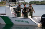 TEXAS, USA: Border Patrol agents point at a sign of activity on the Rio Grande, the river on the Texas-Mexico border. With heightened land enforcement fueling human smuggling by sea, the Border Patrol has had to introduce new boat models for the pursuit of high-speed vehicles.  (Photo Credit: © NGT)