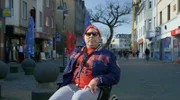 Niko Brenner, alias Dr. Knarf, fährt in seinem Rollstuhl durch Köln-Porz.