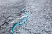 Schmelzwasser fließt im Sommer über die Oberfläche des grönländischen Eisschilds oder bildet Seen. Dringt es durch Risse in den Schild ein, trägt es dazu bei, dessen starre Struktur weiter zu destabilisieren.
