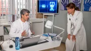Dr. Jonas (Gerit Kling) berät sich mit ihrem Kollegen Dr. Sharif (Atheer Adel) über den Gesundheitszustand ihres Patienten.
