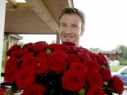 Hans (Heiko Ruprecht) überrascht seine Klara mit einem großen Rosenstrauß.