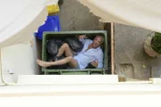 Nico Körner (Christoph M. Ohrt) versucht aus dem Fenster zu steigen und landet dabei im Müllcontainer - nur die Hose ist noch im Hotelzimmer verblieben.