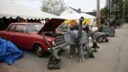 At Brimfield Flea Market dealers booth with a red car with the hood up and large elephant statue with other animal statues around. As seen on HGTV's Flea Market Flip.