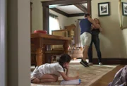 George choking Shauna in their home while their daughter watches nervously.