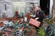 Noah carrying a toolbox in a yard full of wires.