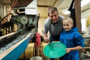 Proud father Shawn poses for a photo with his son Luke, celebrating his first time panning gold.