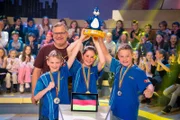 Das blaue Rateteam aus München/Deutschland bejubelt den Sieg: Es darf den begehrten Piet-Flosse-Pokal in die Höhe strecken!