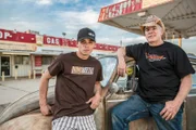 AZN and Farmtruck standing in front of a car at an old gas station.