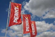 Flags against blue sky with the Logo of Penny Market