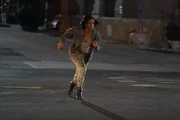 Kai De Vera (Skye P. Marshall) flüchtet vor der Polizei, nachdem sie ein Gebäude überfallen hat.