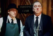 Ludlow (Peter Wight, l.), der Hausmeister der noblen Devington School, und der stolze Direktor Jonathan Eckersley-Hyde (Desmond Barrit, r.), fördern die altehrwürdigen Tradition des Pudding-Clubs.