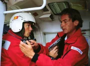 Der Terrorist Hajo (Andreas Patton, l.) zwingt Dr. Lüdwitz (Rainer Grenkowitz) dazu, den Helm richtig an die Intercom-Anlage anzuschließen.