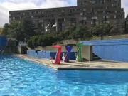 Entertainment-Managerin Cori und Reiseleiter Moritz machen beim Meerjungfrauen-Schwimmkurs in einem Outdoor-Pool in Montreal Trockenübungen.