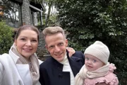 Melanie Bachmann-Häfliger und Markus Häfliger mit ihrer Tochter vor ihrer Villa mit Rustico