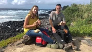 Tamina Kallert (l) und Wanderführer Tiago Botelho machen ein Picknick an der Küste von Mosteiros auf der Hauptinsel Sao Miguel.